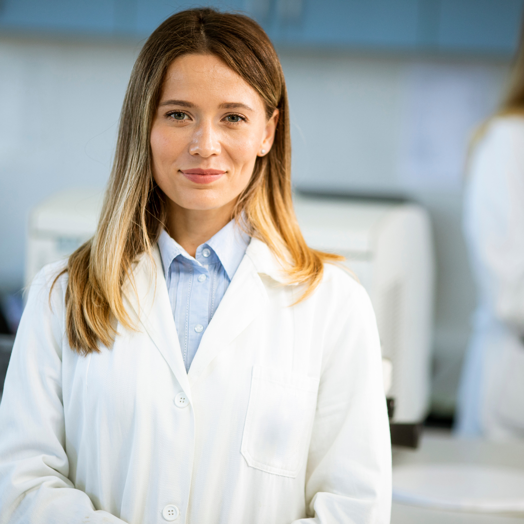 What Is a Trichologist? And why your hair deserves one, professional woman in lab coat smiling